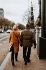 Visão traseira do casal andando pela rua da cidade de mãos dadas — Fotografia de Stock