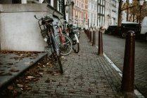 Bicicletas aparcadas en la fila en una de las calles de Ámsterdam - foto de stock