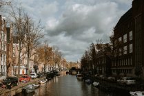Знаменитий Амстердам міський пейзаж з видом на традиційну архітектуру, велосипеди, міст через канал, причалюють човни — стокове фото