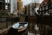 Amsterdam vista paisagem urbana com arquitetura tradicional, bicicletas, ponte sobre o canal e barco ancorado — Fotografia de Stock