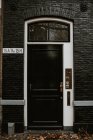 Vista de la típica entrada de la casa holandesa con interfono por puerta de madera negra - foto de stock