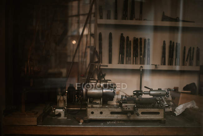 Вид на шлифовальный станок в окне мастерской за стеклом — стоковое фото