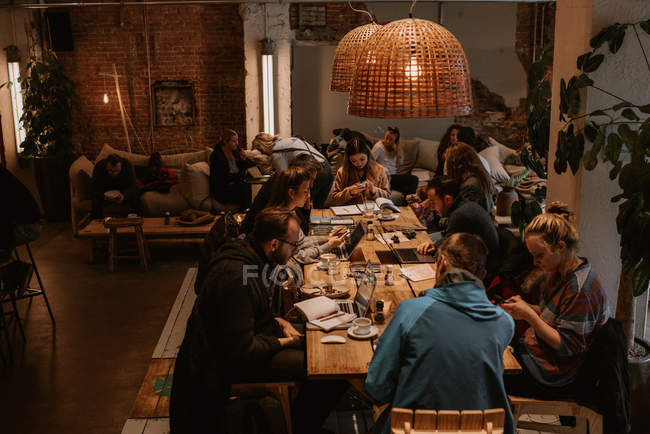 Personnes assises à la table en coworking ayant une réunion ensemble — Photo de stock