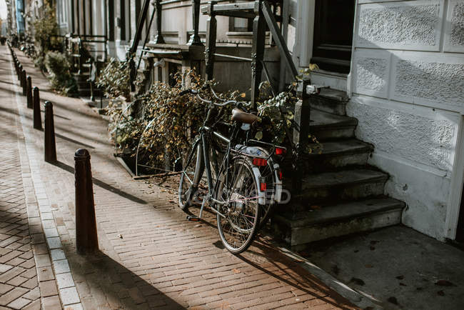 Escena otoñal con arquitectura holandesa típica y bicicletas aparcadas junto a la entrada de la casa, Amsterdam, Países Bajos - foto de stock