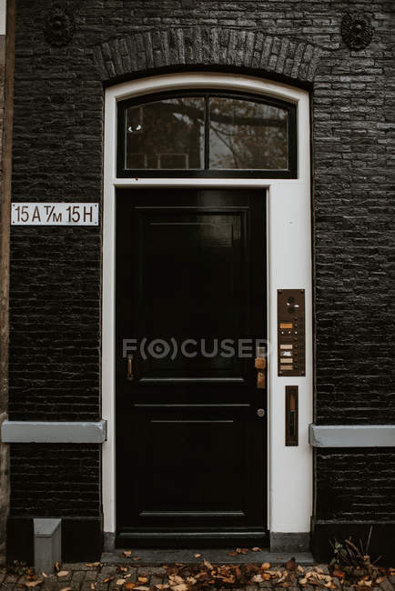 Вид на типичный вход в дачный дом с домофоном через черную деревянную дверь — стоковое фото