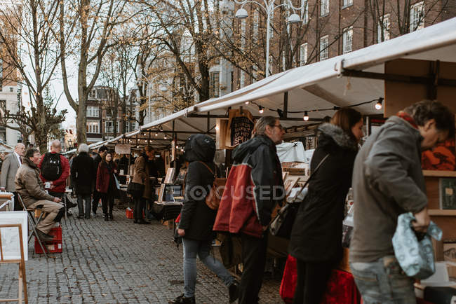 С людьми, гуляющими на уличном рынке сувениров — стоковое фото