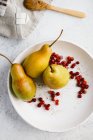 Pears and lingonberries on plate — Stock Photo