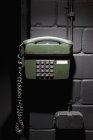 Telefone antiquado verde na parede de tijolos — Fotografia de Stock