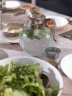 Um jarro de água e um copo em uma mesa de jantar — Fotografia de Stock