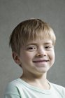 Ritratto di ragazzo sorridente su sfondo grigio — Foto stock