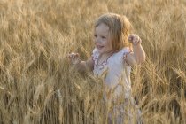 Chica feliz caminando en el campo de trigo - foto de stock