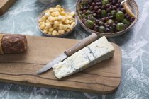 Vue rapprochée des tranches de fromage aux olives et aux maïs doux sur la table — Photo de stock