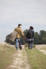Молода пара, тримаючись за руки і прогулянки по бруду відстеження — стокове фото