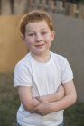 Retrato de um menino com os braços cruzados no quintal — Fotografia de Stock
