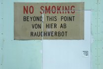 No smoking sign in German and English on door — Stock Photo