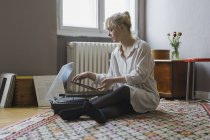 Woman playing record while sitting at home — Stock Photo