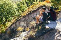 High angle view of friends sitting on mountain at forest — Stock Photo