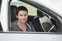 Портрет середини дорослої жінки, що сидить у машині — стокове фото