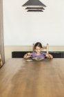 Menina ter comida na mesa de jantar em casa — Fotografia de Stock