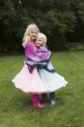 Ritratto di ragazza felice abbracciare sorella mentre in piedi in cortile — Foto stock