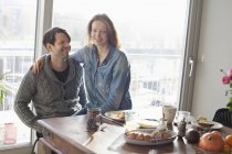 Couple souriant assis à table avec petit déjeuner — Photo de stock