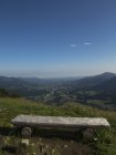 Asiento de madera sobre el paisaje de montaña contra el cielo azul - foto de stock