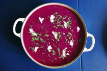 Directly below shot of beetroot soup served in cooking pan on blue table — Stock Photo