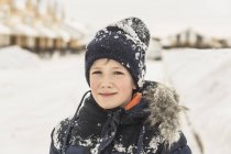 Retrato de niño confiado en ropa de invierno cubierto de nieve - foto de stock
