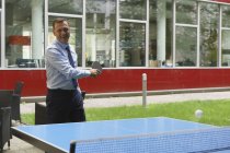Homme d'affaires heureux confiant jouant au tennis de table dans un bureau créatif — Photo de stock