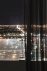 Illuminated cityscape seen through curtains on window, Las Vegas, Nevada, USA — Stock Photo