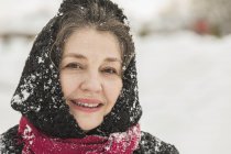 Retrato de mujer mayor sonriente en ropa de invierno cubierta de nieve - foto de stock