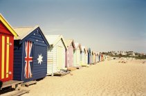 Fila de coloridas cabañas de playa con bandera australiana en el día de verano - foto de stock