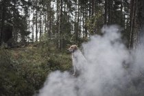Perro sentado por el humo en el bosque - foto de stock