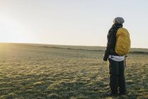 Vista posteriore di escursionista donna in piedi sul campo di campagna contro il cielo limpido — Foto stock