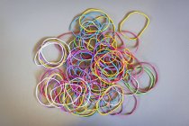 Directly above shot of multi colored rubber bands on gray background — Stock Photo