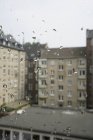 Edificios contra el cielo vistos a través de ventana de vidrio húmedo - foto de stock