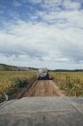 Внедорожник, движущийся по грунтовой дороге среди растений в поле против неба, Свободный, Амур, Россия — стоковое фото