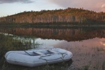 Zattera gonfiabile vuota ormeggiata sulla riva del lago contro foresta, Svobodniy, Amur, Russia — Foto stock