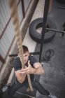 Male athlete climbing rope during crossfit training — Stock Photo