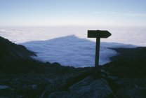 Shadow of mountain peak over foggy canyon — Stock Photo