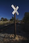 Railroad crossing signal post countryside in dusk — Stock Photo