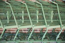 Side view of stacked empty shopping trolleys in row — Stock Photo
