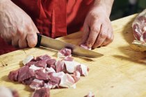 Coltivare mani maschili tagliando carne a bordo — Foto stock