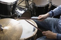 Обтинання барабанщик руки з drumersticks на барабанну установку — стокове фото
