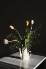 Still life of bouquet of tulips in watering can on table — Stock Photo