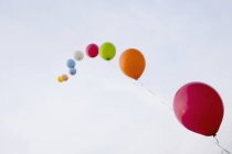 Palloncini di elio legati ad una corda fluttuante nel cielo — Foto stock