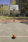 Empty outdoor basketball court and basketball on asphalt — Stock Photo