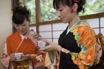 Dos mujeres con kimonos bebiendo té - foto de stock