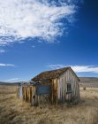Vista esterna della baracca di legno in campo arido — Foto stock