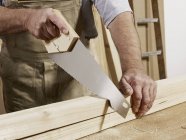 Midsection of man sawing wood — Stock Photo